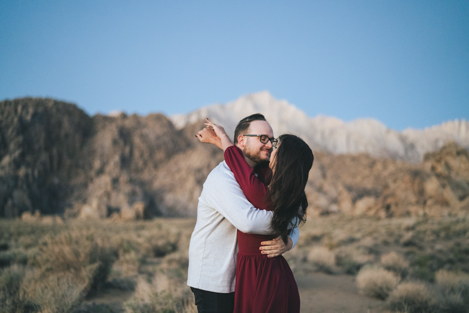 Engaged couple wearing a red dress in the Alabama Hills