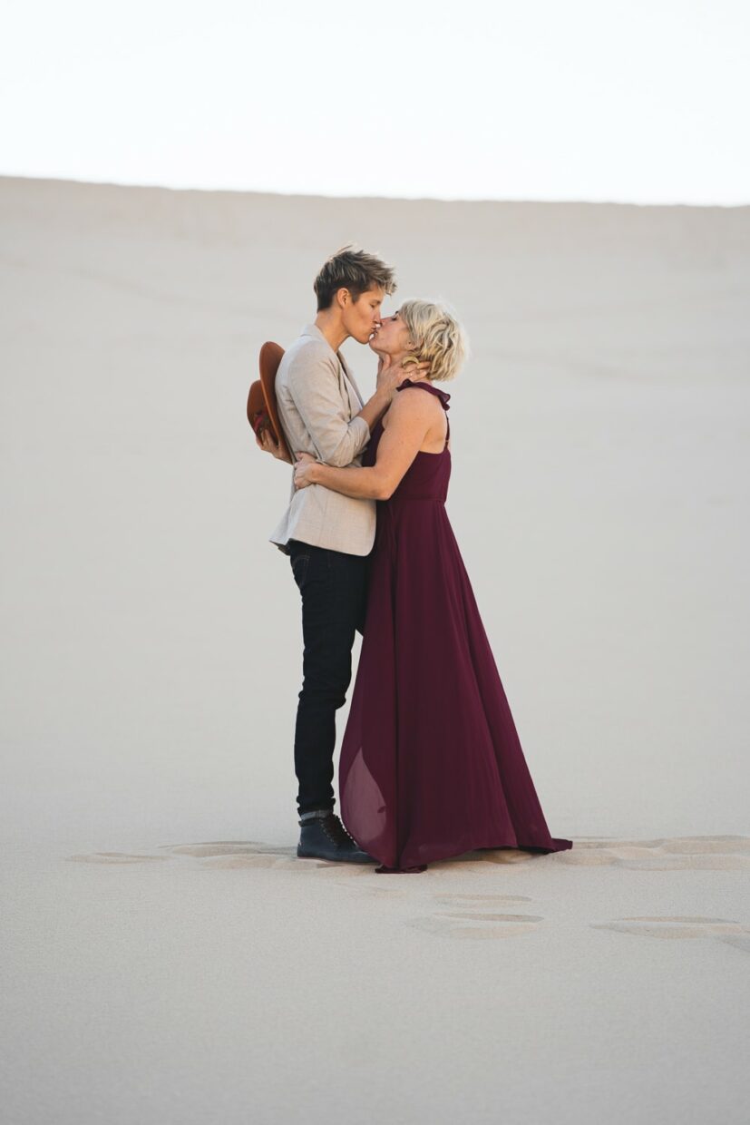 Two brides in the Death Valley Sand dunes, with a bohemian style flowy red dress