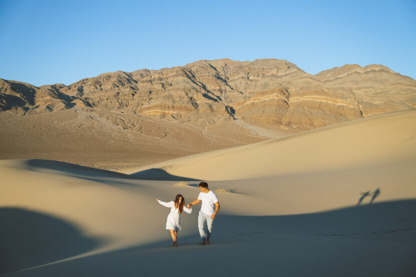 Engaged couple wearing white in the Eureka Sand Dunes