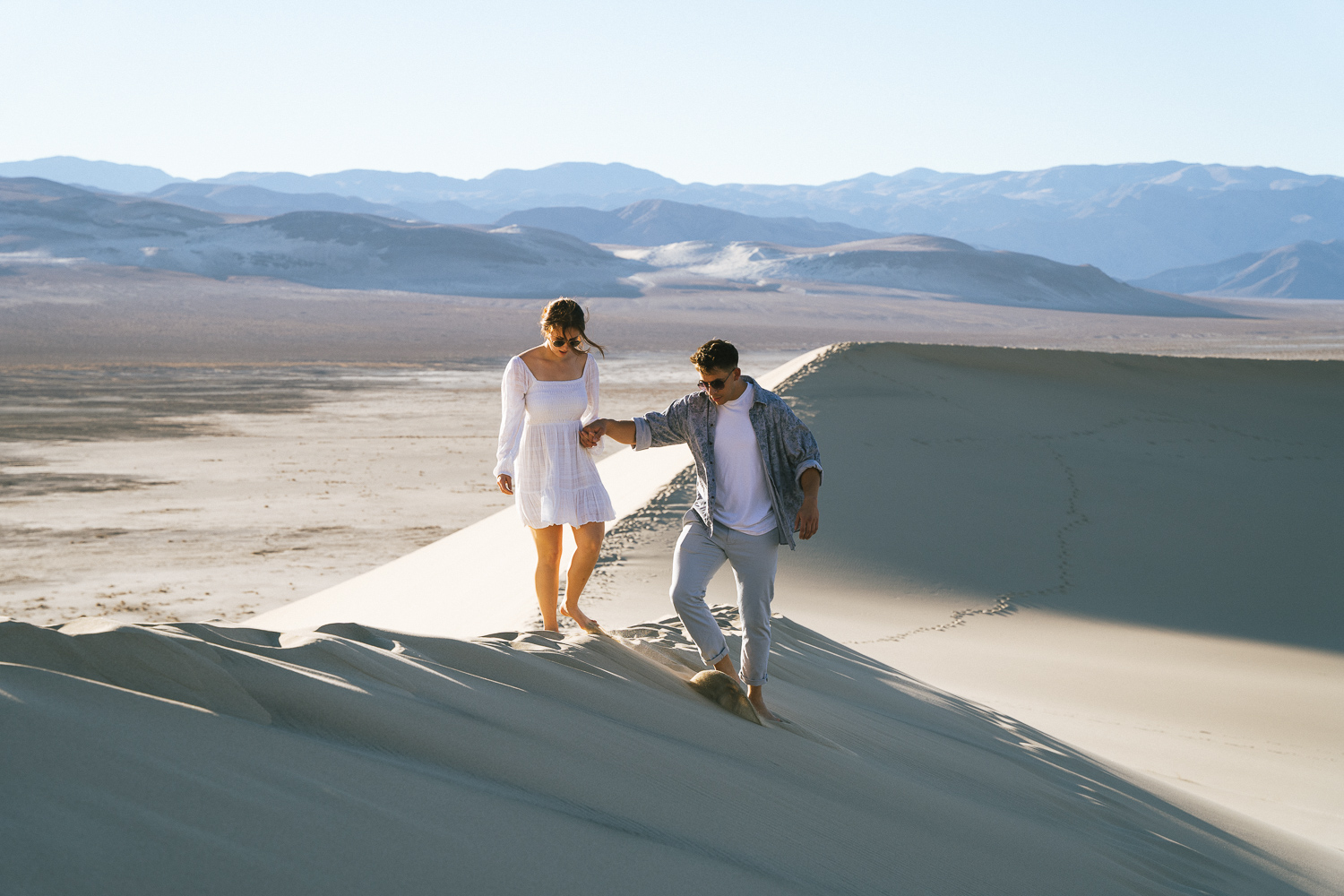 Engaged couple wearing white in the Eureka Sand Dunes