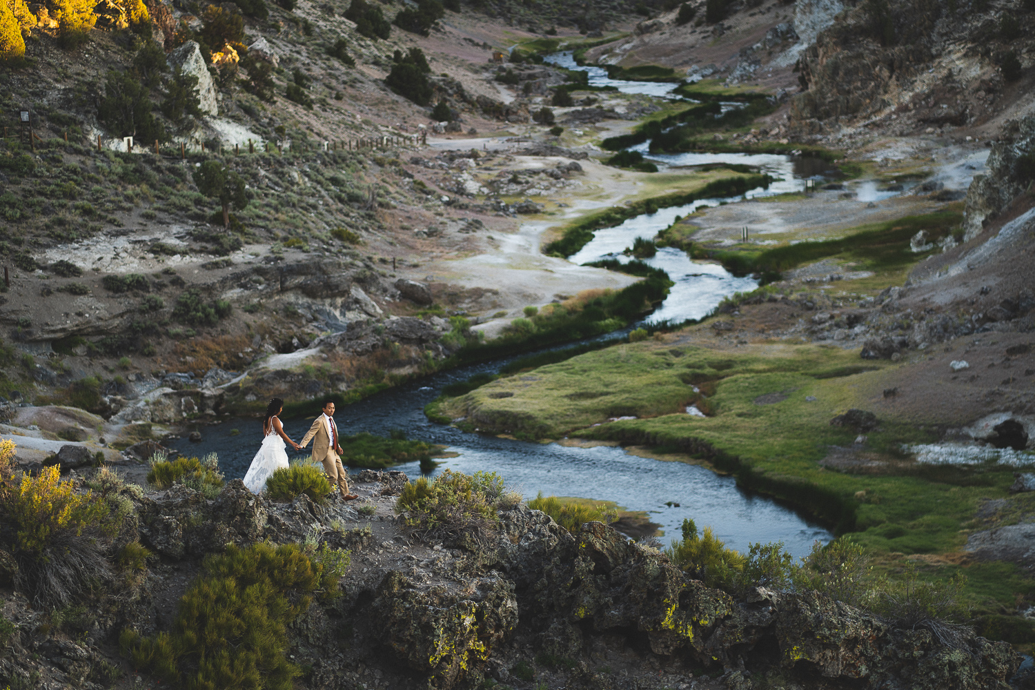 wedding couple walking across the owens river